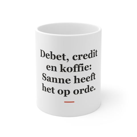 Mok met tekst “Debet, credit en koffie: Sanne heeft het op orde.” — cadeau voor een accountant