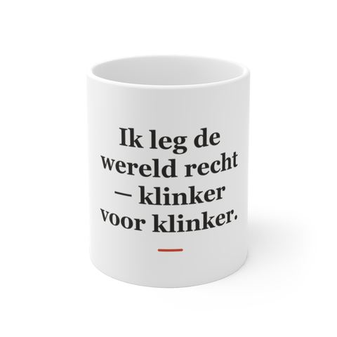 Mok met tekst “Ik leg de wereld recht — klinker voor klinker.” — cadeau voor een stratenmaker